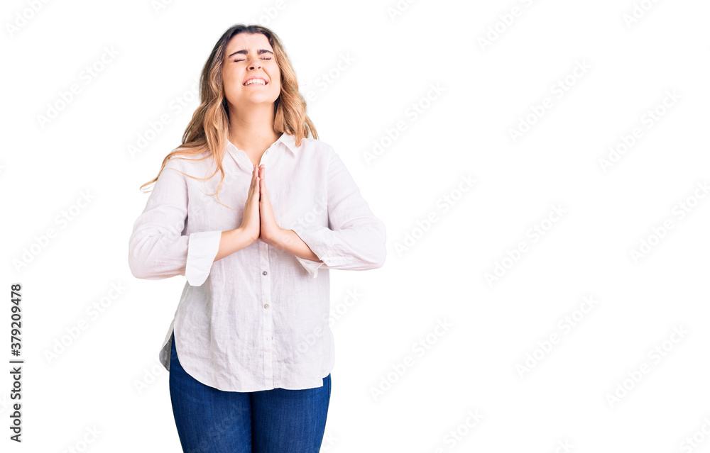 Young caucasian woman wearing casual clothes begging and praying with hands together with hope expression on face very emotional and worried. begging. Young caucasian woman wearing casual clothes begging and praying with hands together with hope expression on face very emotional and worried. begging.