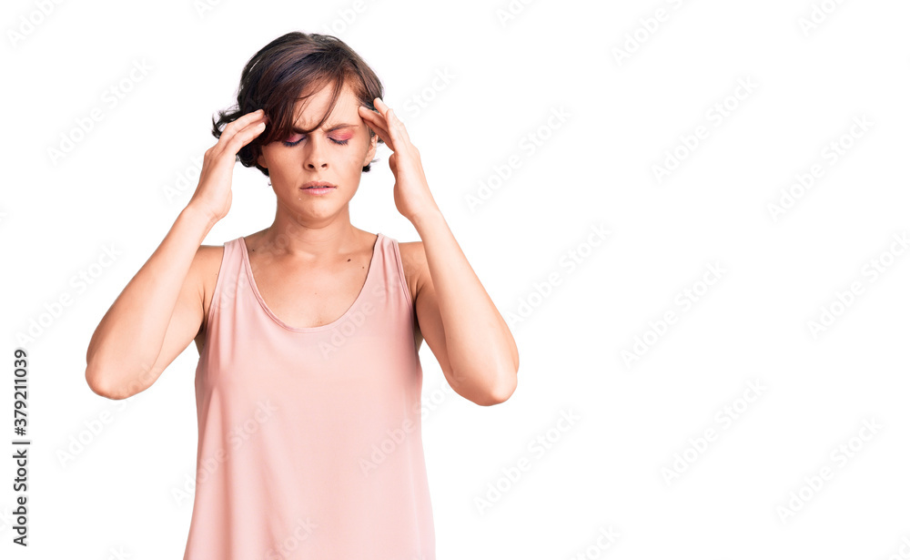 Beautiful young woman with short hair wearing casual style with sleeveless shirt with hand on head for pain in head because stress. suffering migraine. Beautiful young woman with short hair wearing casual style with sleeveless shirt with hand on head for pain in head because stress. suffering migraine.