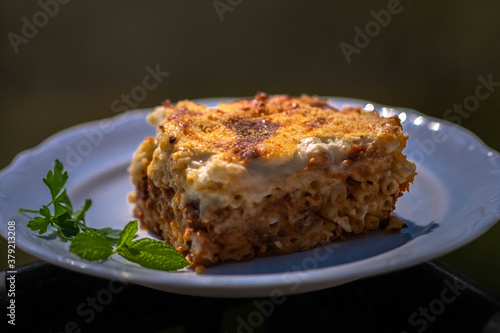 Preparing traditional greek food recipe. Baked pasta casserole pastitsio with rich bechamel sauce and ground beef.
