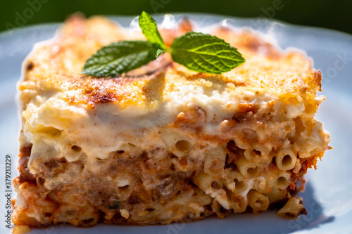 Preparing traditional greek food recipe. Baked pasta casserole pastitsio with rich bechamel sauce and ground beef.