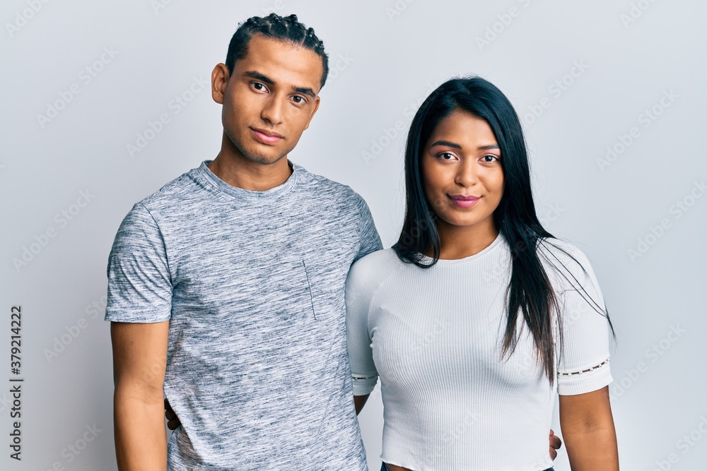 Young latin couple wearing casual clothes relaxed with serious expression on face. simple and natural looking at the camera. Young latin couple wearing casual clothes relaxed with serious expression on face. simple and natural looking at the camera.