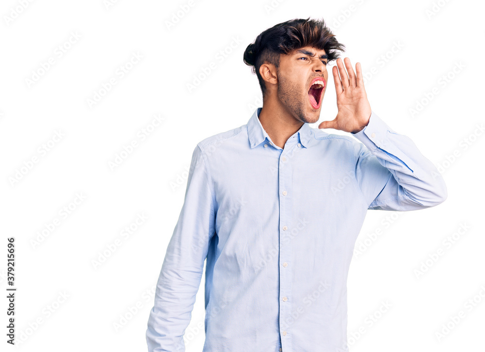 Young hispanic man wearing casual shirt shouting and screaming loud to side with hand on mouth. communication concept. Young hispanic man wearing casual shirt shouting and screaming loud to side with hand on mouth. communication concept.