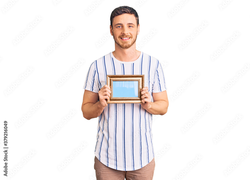 Handsome young man with bear holding empty frame looking positive and happy standing and smiling with a confident smile showing teeth Handsome young man with bear holding empty frame looking positive and happy standing and smiling with a confident smile showing teeth