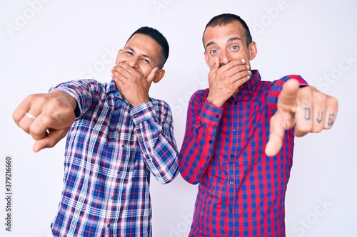 Foto Young gay couple of two men wearing casual clothes laughing at you, pointing fin