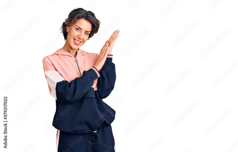 Young beautiful woman wearing sportswear clapping and applauding happy and joyful, smiling proud hands together Young beautiful woman wearing sportswear clapping and applauding happy and joyful, smiling proud hands together