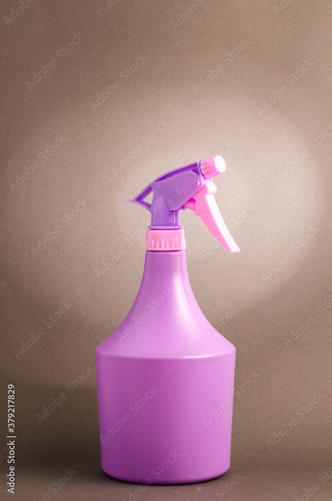 bottle with spray on brown background/purple spray bottle isolated on brown background bottle with spray on brown background/purple spray bottle isolated on brown background