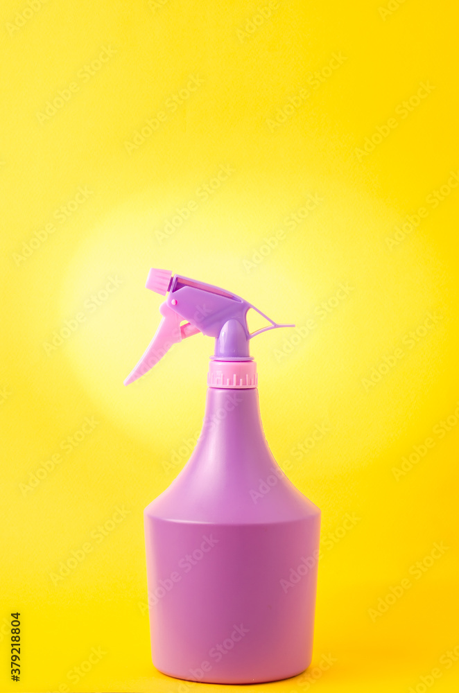 bottle with spray on yellow grey background/purple spray bottle isolated on yellow background bottle with spray on yellow grey background/purple spray bottle isolated on yellow background