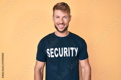 Young caucasian man wearing security t shirt with a happy and cool smile on face. lucky person.