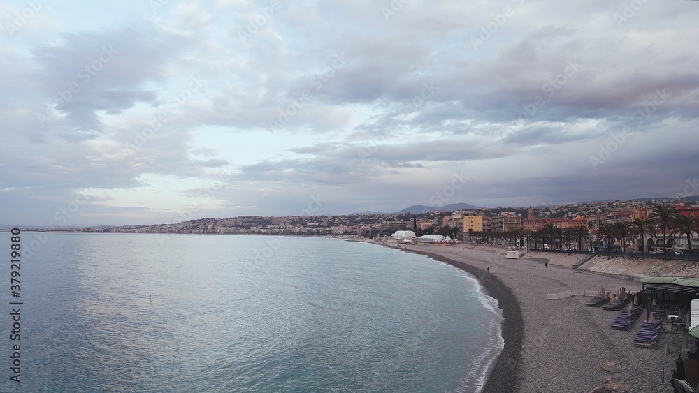 South city with a coastline, houses near a big sea in Nice, France. Cloudy day, drone shot of long extended shoreline, cloudy windy day, pebbles beach