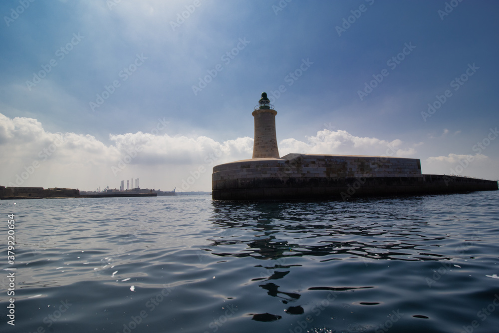 lighthouse by valetta city. ligthouse at sea. Grand Harbor at the City of Valletta, Malta. boatt background