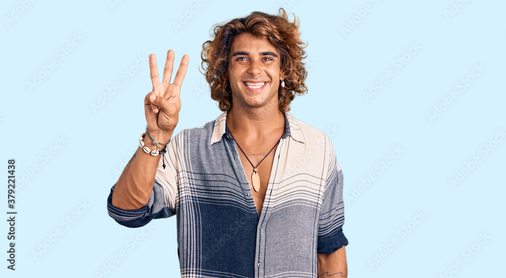 Young hispanic man wearing summer style showing and pointing up with fingers number three while smiling confident and happy. Young hispanic man wearing summer style showing and pointing up with fingers number three while smiling confident and happy.