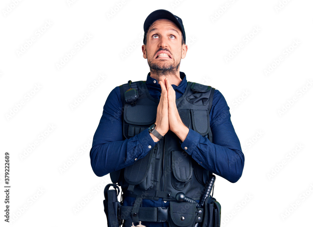Young handsome man wearing police uniform begging and praying with hands together with hope expression on face very emotional and worried. begging. Young handsome man wearing police uniform begging and praying with hands together with hope expression on face very emotional and worried. begging.