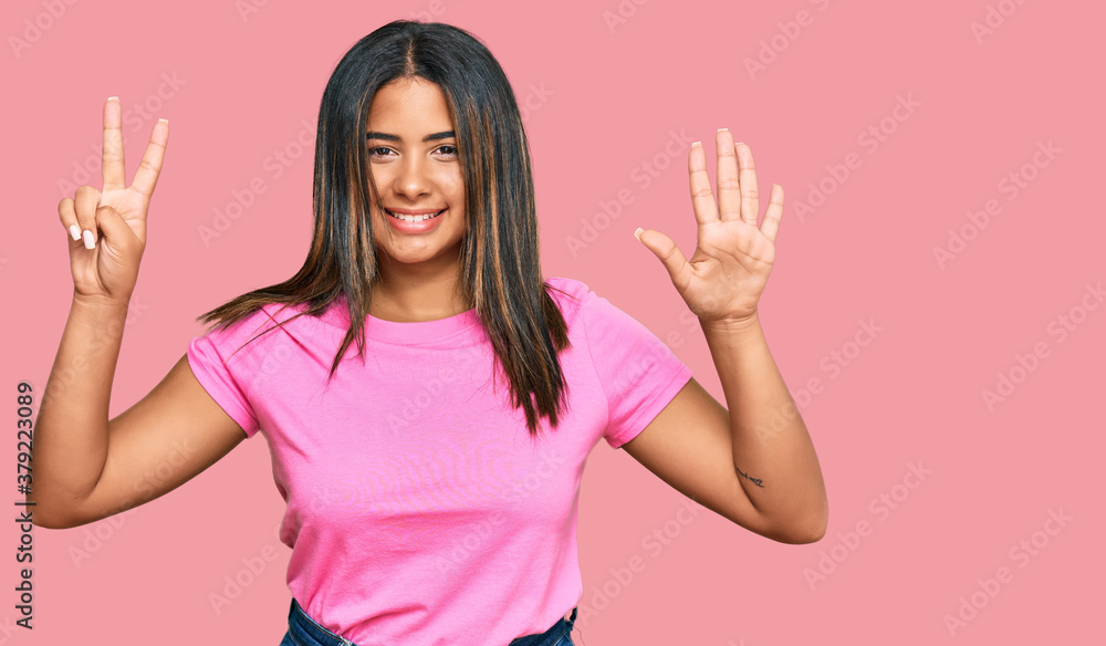 Young latin girl wearing casual clothes showing and pointing up with fingers number seven while smiling confident and happy. Young latin girl wearing casual clothes showing and pointing up with fingers number seven while smiling confident and happy.