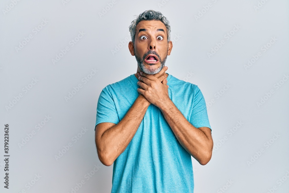 Middle age grey-haired man wearing casual clothes shouting and suffocate because painful strangle. health problem. asphyxiate and suicide concept. Middle age grey-haired man wearing casual clothes shouting and suffocate because painful strangle. health problem. asphyxiate and suicide concept.