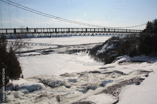 Beautiful Montmorency falls with snow in winter and the typical bridge, Quebec, Canada