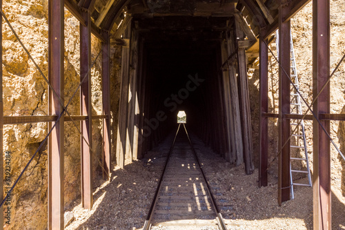 Dark tracks leading into train tunnel with opening in the middle at the end