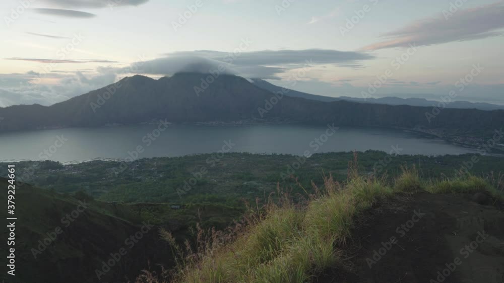 Traveler man standing on top active volcano Mount Batur Bali and enjoy beautiful view from the top. Mount Batur Sunrise Trekking - one of the most popular tourist destination in Bali, Indonesia. 4K Traveler man standing on top active volcano Mount Batur Bali and enjoy beautiful view from the top. Mount Batur Sunrise Trekking - one of the most popular tourist destination in Bali, Indonesia. 4K