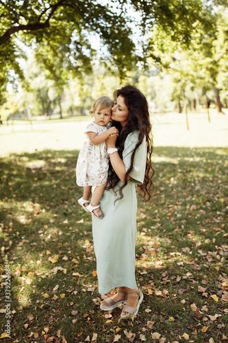 Portrait of amazing mother with cute little daughter walking in the forest. Family concept.