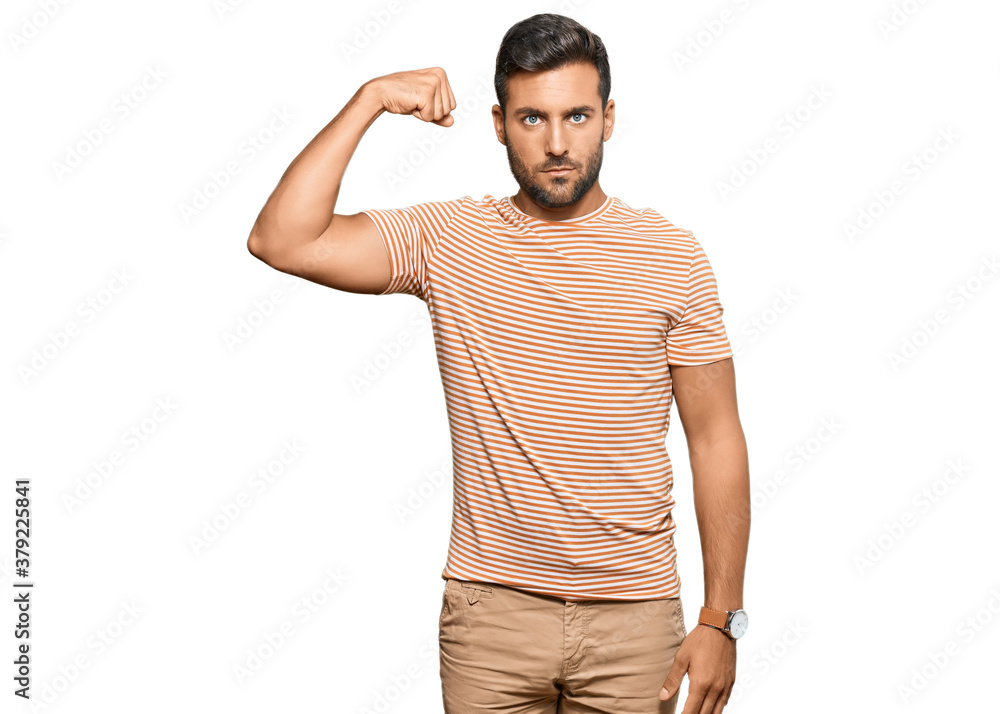 Handsome hispanic man wearing casual clothes strong person showing arm muscle, confident and proud of power Handsome hispanic man wearing casual clothes strong person showing arm muscle, confident and proud of power