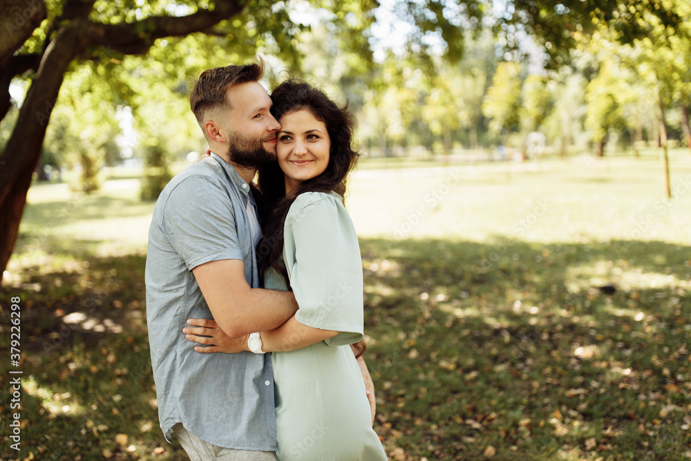 Lovely couple smiling in the garden. Wife and husband holding each other in the beautiful place. Happy marriage concept. Lovely couple smiling in the garden. Wife and husband holding each other in the beautiful place. Happy marriage concept.