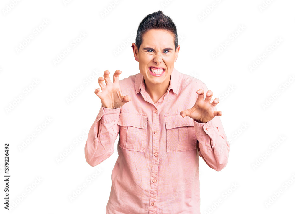 Young woman with short hair wearing casual clothes smiling funny doing claw gesture as cat, aggressive and sexy expression Young woman with short hair wearing casual clothes smiling funny doing claw gesture as cat, aggressive and sexy expression