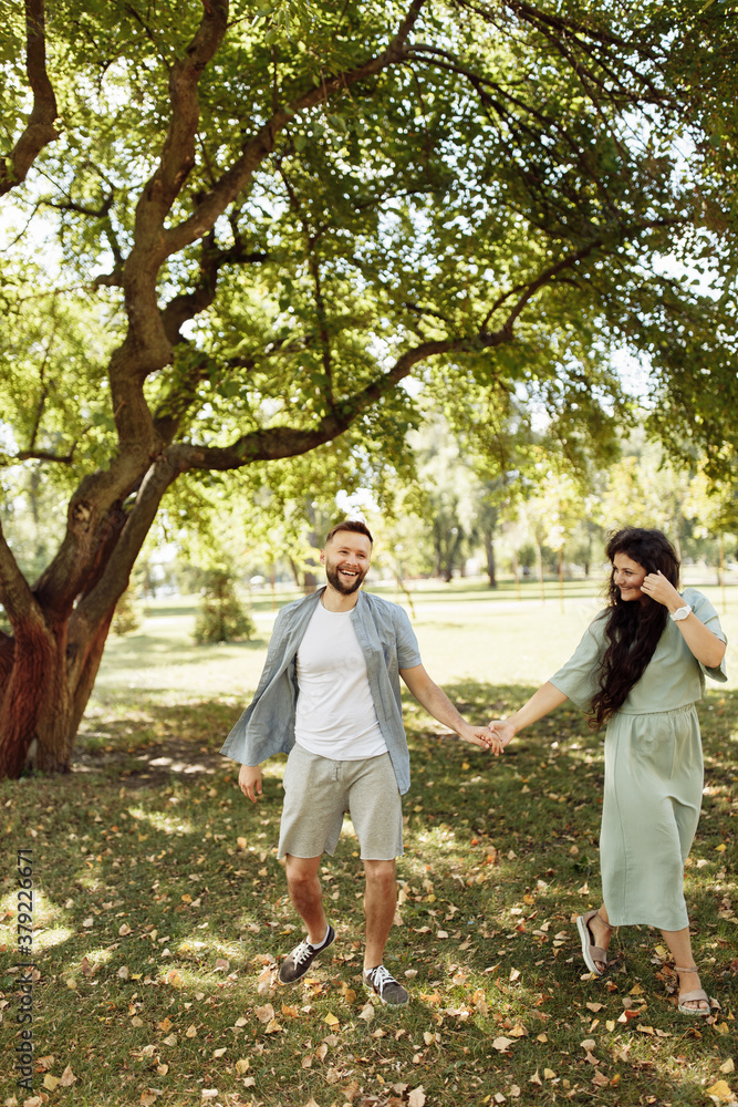 Lovely couple smiling in the garden. Wife and husband holding each other in the beautiful place. Happy marriage concept. Lovely couple smiling in the garden. Wife and husband holding each other in the beautiful place. Happy marriage concept.