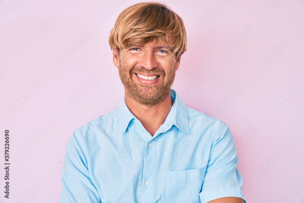 Young blond man wearing casual clothes happy face smiling with crossed arms looking at the camera. positive person. Young blond man wearing casual clothes happy face smiling with crossed arms looking at the camera. positive person.