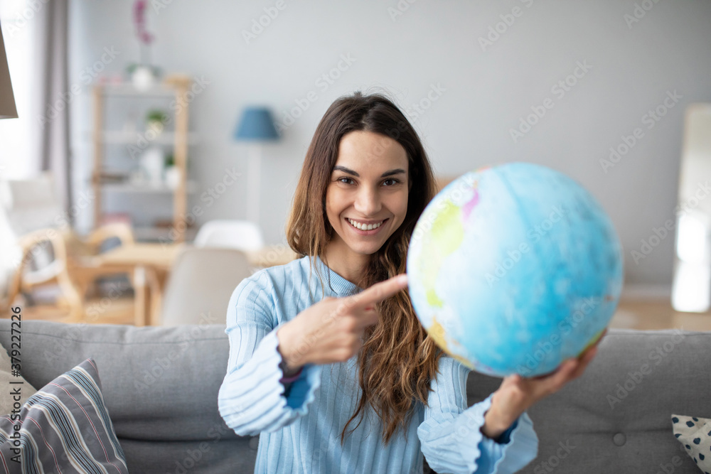 Woman dreaming about travel, pointing with index finger at globe. Planning vacation. Woman dreaming about travel, pointing with index finger at globe. Planning vacation.