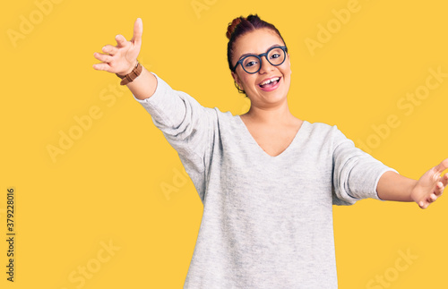 Young latin woman wearing casual clothes looking at the camera smiling with open arms for hug. cheerful expression embracing happiness.