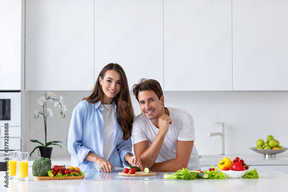 Couple cooking salad of fresh vegetables in the kitchen. Couple cooking salad of fresh vegetables in the kitchen.