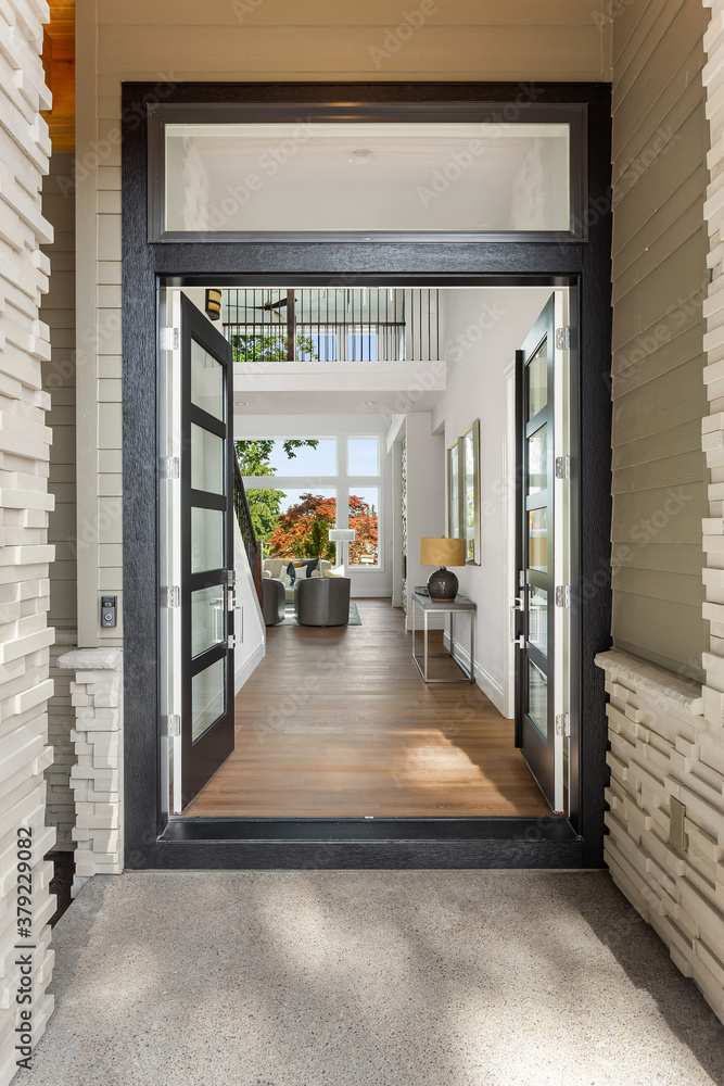 Luxury home exterior with front doors open, visitors to enter