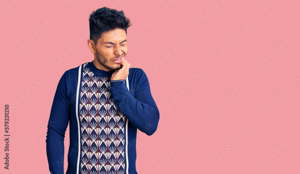 Handsome latin american young man wearing casual winter sweater touching mouth with hand with painful expression because of toothache or dental illness on teeth. dentist Handsome latin american young man wearing casual winter sweater touching mouth with hand with painful expression because of toothache or dental illness on teeth. dentist