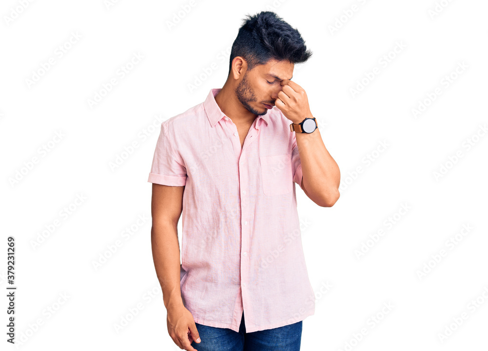 Handsome latin american young man wearing casual summer shirt tired rubbing nose and eyes feeling fatigue and headache. stress and frustration concept. Handsome latin american young man wearing casual summer shirt tired rubbing nose and eyes feeling fatigue and headache. stress and frustration concept.