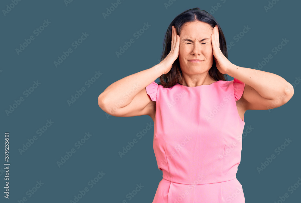Young beautiful brunette woman wearing casual dress suffering from headache desperate and stressed because pain and migraine. hands on head. Young beautiful brunette woman wearing casual dress suffering from headache desperate and stressed because pain and migraine. hands on head.