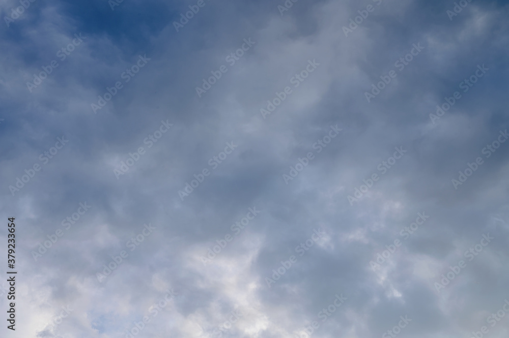 Abstract background of white fluffy clouds on a bright blue sky