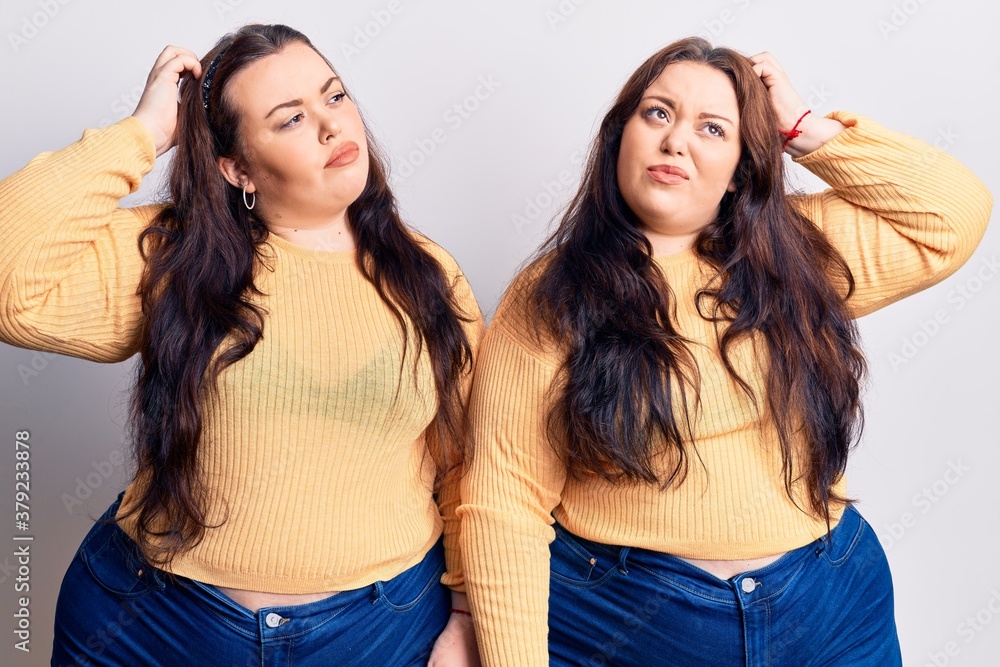 Young plus size twins wearing casual clothes confuse and wondering about question. uncertain with doubt, thinking with hand on head. pensive concept. Young plus size twins wearing casual clothes confuse and wondering about question. uncertain with doubt, thinking with hand on head. pensive concept.