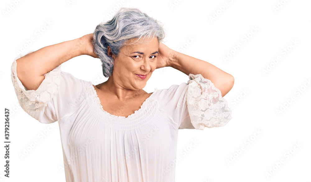 Senior woman with gray hair wearing bohemian style relaxing and stretching, arms and hands behind head and neck smiling happy Senior woman with gray hair wearing bohemian style relaxing and stretching, arms and hands behind head and neck smiling happy