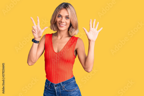 Beautiful caucasian woman wearing casual clothes showing and pointing up with fingers number eight while smiling confident and happy.
