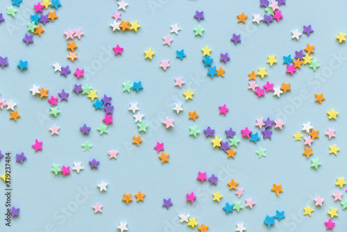 Trendy plastic colorful stars confetti on blue background. Birthday party festive polymer clay decoration. New Year, Christmas celebration, holidays, dreams and winter concept