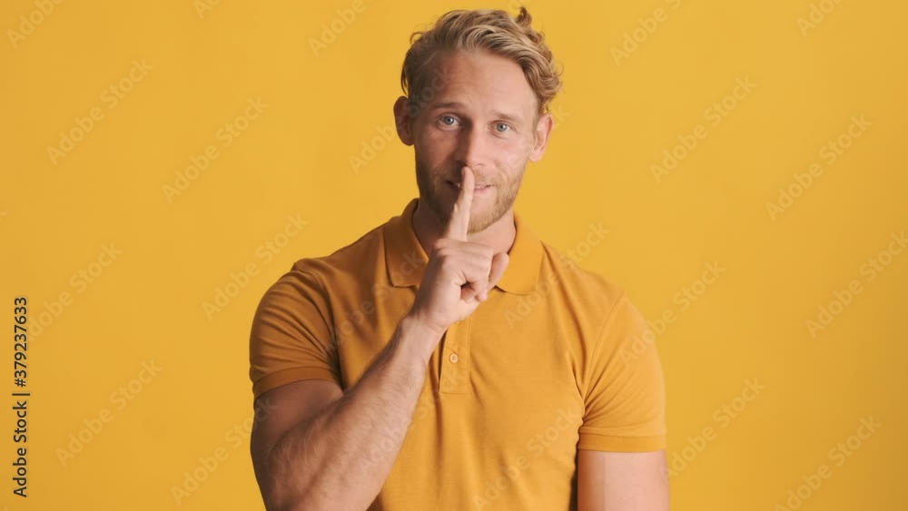Attractive blond bearded guy showing silence gesture on camera over colorful background. Keep secret expression Attractive blond bearded guy showing silence gesture on camera over colorful background. Keep secret expression