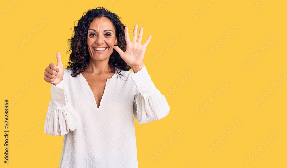Middle age beautiful woman wearing casual sweater showing and pointing up with fingers number six while smiling confident and happy. Middle age beautiful woman wearing casual sweater showing and pointing up with fingers number six while smiling confident and happy.
