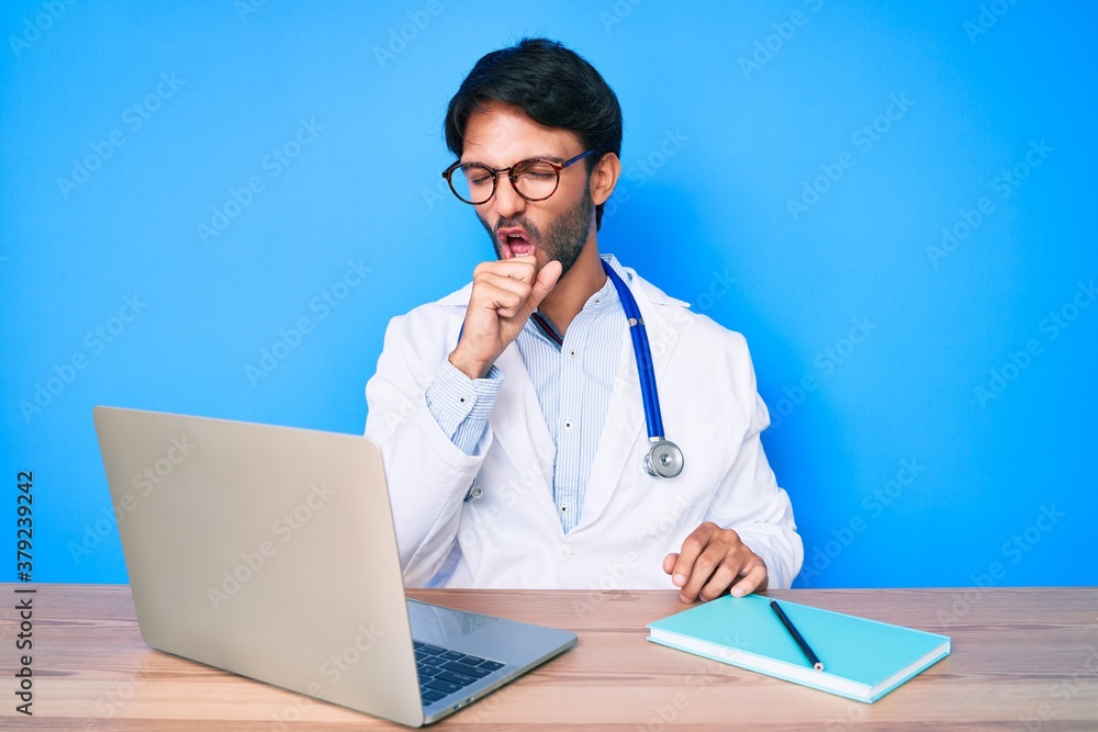 Handsome hispanic man wearing doctor uniform working at the clinic feeling unwell and coughing as symptom for cold or bronchitis. health care concept. - obrazy, fototapety, plakaty 