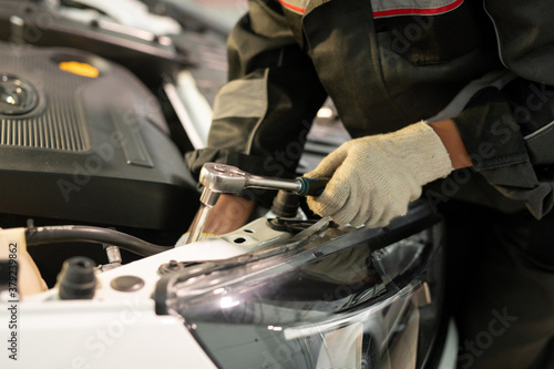 Gloved hand of worker of contemporary car maintenance center using handtool © pressmaster