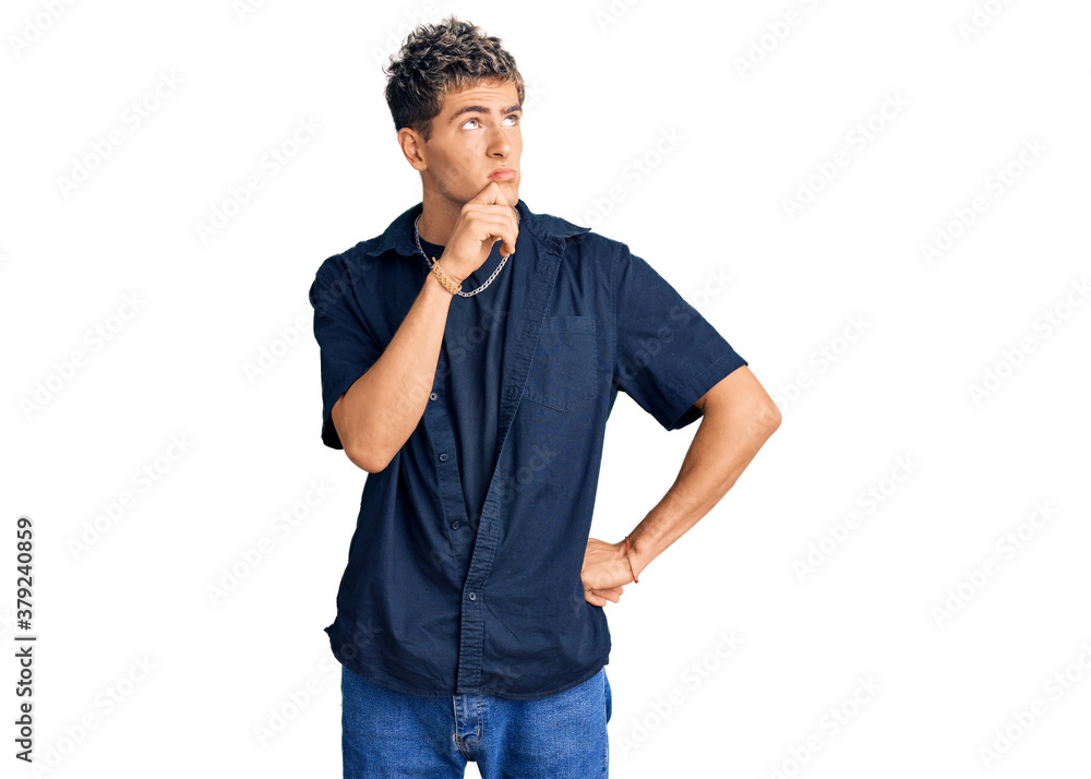 Young handsome man wearing casual clothes serious face thinking about question with hand on chin, thoughtful about confusing idea Young handsome man wearing casual clothes serious face thinking about question with hand on chin, thoughtful about confusing idea