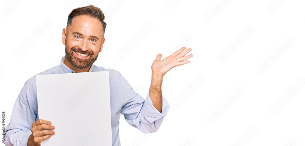 Handsome middle age man holding blank empty banner celebrating victory with happy smile and winner expression with raised hands Handsome middle age man holding blank empty banner celebrating victory with happy smile and winner expression with raised hands