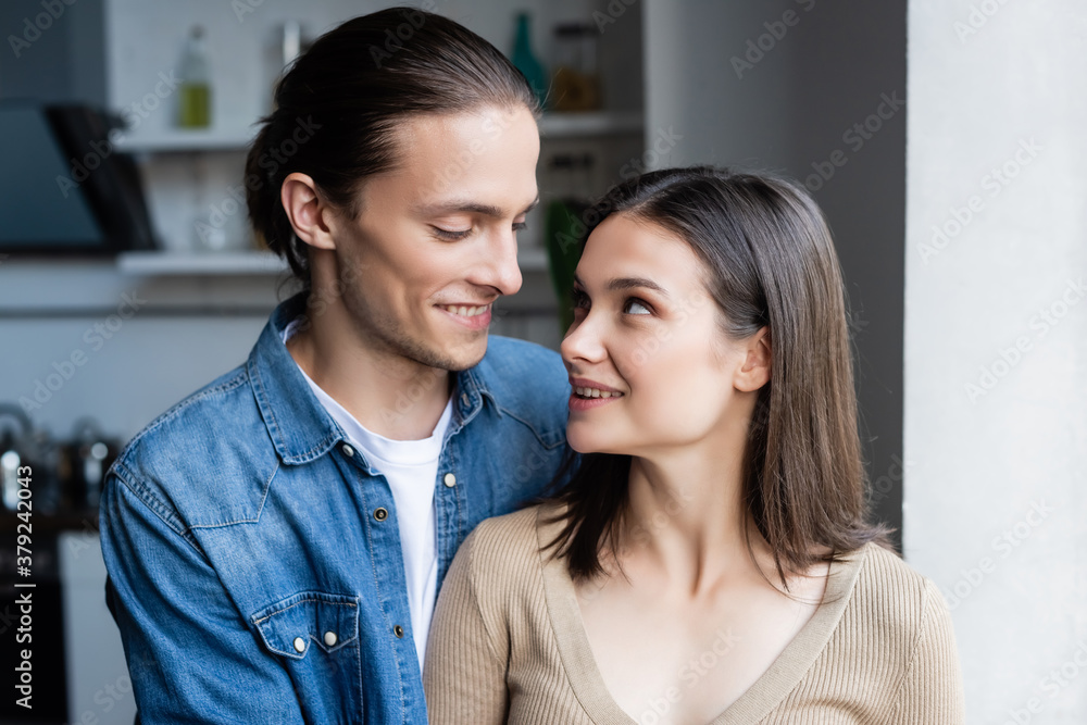 young couple looking at each other while standing together at home young couple looking at each other while standing together at home
