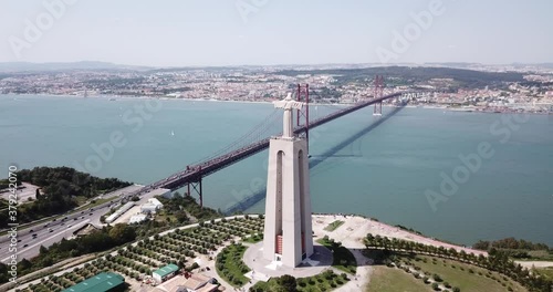 Aerial view ovet the April of 25 bridge in Lisbon, crossing the Tagus River and Statue of Jesus , Portugal photo