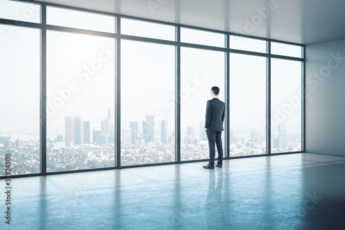 Young businessman looking on window in contemporary office
