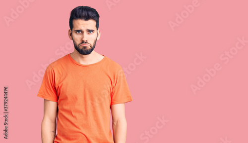 Young handsome man with beard wearing casual t-shirt depressed and worry for distress, crying angry and afraid. sad expression.