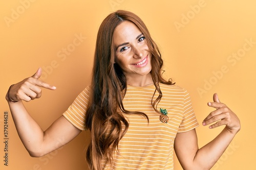 Young brunette woman wearing casual clothes looking confident with smile on face, pointing oneself with fingers proud and happy.